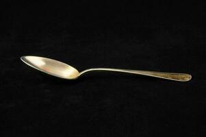 a silver spoon on a black background photo