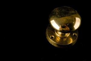 a close up of a brass knob on a black background photo