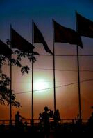 the sun sets behind the flags of vietnam and cambodia photo