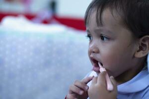 un cuidando madre suavemente cepillos su pequeño hija dientes para bueno dental salud. foto