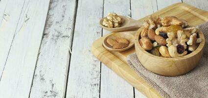 Bowl of mixed nut and berry on white wooden background photo