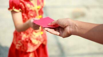 Hand give money in red envelop to another - Chinese new year photo