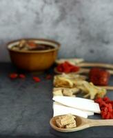 Spoon of  Radix Codonopsis Pilosulae and many chinese herbs on black background photo