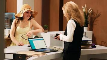 Hotel concierge verifying id papers to check in guests at tropical resort, looking at personal documents in reception lobby. Receptionist registering tourists with passports, leisure. photo