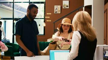 Hotel guests showing passports at front desk, using id documents for check in registration procedure. Receptionist verifying identification papers to register people at resort. photo