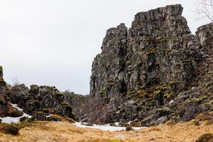 masivo montaña rango en nórdico configuración, islandés rocoso picos en magnífico gloria de thingvellir nacional parque. acantilados formado por tierras altas rock formaciones cerca a islandés región. foto