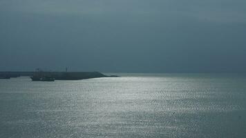 The peaceful sea view with the fishing boat sailing on it in the cloudy day photo