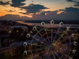 hermosa puesta de sol terminado el ciudad con un iluminado ferris rueda. foto
