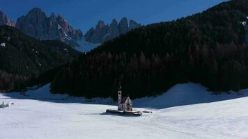 Igreja do santo John, floresta e dolomites em ensolarado inverno dia. sul Tirol, Itália. aéreo visualizar. órbita sentido anti-horário video