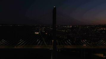 iluminado vasco da gama estaiada ponte e Lisboa paisagem urbana às tarde crepúsculo. Lisboa, Portugal. azul hora. aéreo visualizar. órbita. médio tiro video