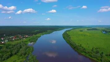 ok rio, verde Prado e floresta em ensolarado verão dia. azul céu com nuvens. panorama do Rússia. aéreo visualizar. zangão moscas para trás e para cima video