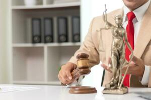 gavel wood Brass scales and a statue of Themis Lady Justice are placed on the tables of the lawyers in the legal counsel's office as a symbol of justice. Concept building trust with symbols of justice photo
