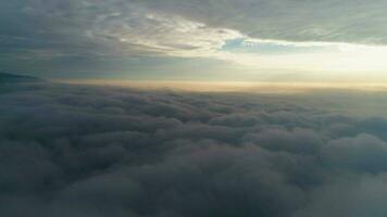 Flying to the right above beautiful dramatic clouds at sunrise. Aerial view video