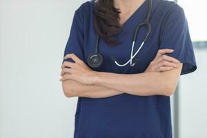 medical professional or doctor stands inside doctor office preparing to check on patients at regular intervals. female doctor prepares for treatment of patients in the hospital. Copy Space for text photo