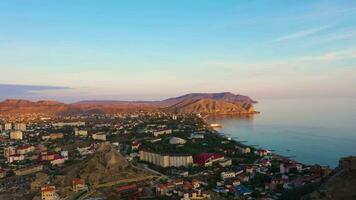 Sudak Stadt und Meganom Kap auf ein Sommer- Morgen. Krim, Russland. Antenne Sicht. Drohne fliegt nach vorne video