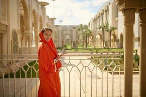 mujer turista vistiendo auténtico vestir y hijab mientras visitando el hassan ii mezquita en casablanca. personas y turismo foto