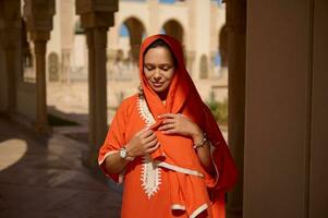 hermosa mujer en marroquí tradicional vestir y cabeza bufanda, en contra beige mármol columnas y arcos antecedentes foto