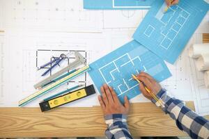 Architects and construction engineers meet to discuss blueprints of building structures in order to calculate the completion of the construction project. Real estate construction business concept. photo