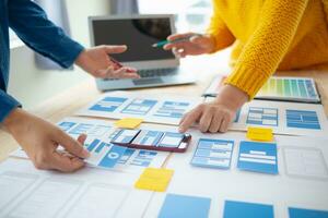 The designer team is designing the uxui system to make the uxui system work well on new phones and support system updates. Website development concept UI UX front end designer photo