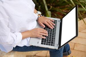 ver desde encima de hembra gerente manos mecanografía texto en ordenador portátil teclado. blanco blanco Bosquejo pantalla con Copiar anuncio espacio foto