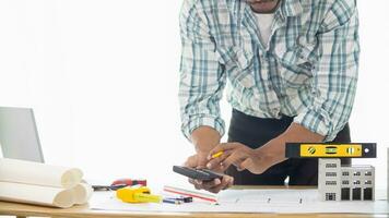 Construction engineers are checking blueprints and calculating their accuracy after receiving plans from architect in order start  construction safely. Inspection Concept from construction engineering photo