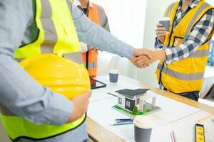 Architects and construction engineering handshake after meeting discuss structural blueprints calculate project completion. cooperation and handshake between of construction engineers and architects. photo