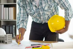 Construction engineers are checking blueprints and calculating their accuracy after receiving plans from architect in order start  construction safely. Inspection Concept from construction engineering photo