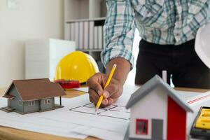 Construction engineers are checking blueprints and calculating their accuracy after receiving plans from architect in order start  construction safely. Inspection Concept from construction engineering photo