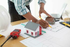 Construction engineers are checking blueprints and calculating their accuracy after receiving plans from architect in order start  construction safely. Inspection Concept from construction engineering photo
