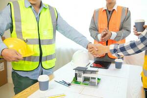Architects and construction engineering handshake after meeting discuss structural blueprints calculate project completion. cooperation and handshake between of construction engineers and architects. photo