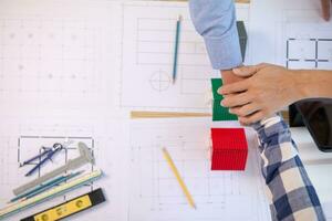 Architects and construction engineering handshake after meeting discuss structural blueprints calculate project completion. cooperation and handshake between of construction engineers and architects. photo