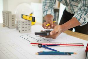 Construction engineers are checking blueprints and calculating their accuracy after receiving plans from architect in order start  construction safely. Inspection Concept from construction engineering photo