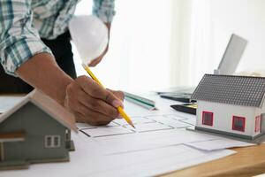 Construction engineers are checking blueprints and calculating their accuracy after receiving plans from architect in order start  construction safely. Inspection Concept from construction engineering photo