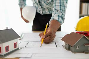 Construction engineers are checking blueprints and calculating their accuracy after receiving plans from architect in order start  construction safely. Inspection Concept from construction engineering photo