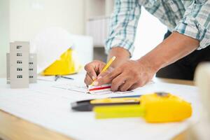Construction engineers are checking blueprints and calculating their accuracy after receiving plans from architect in order start  construction safely. Inspection Concept from construction engineering photo