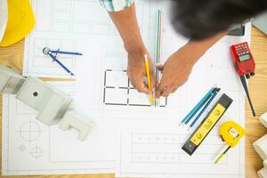 Construction engineers are checking blueprints and calculating their accuracy after receiving plans from architect in order start  construction safely. Inspection Concept from construction engineering photo