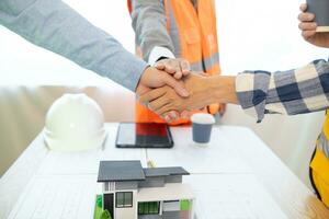 Architects and construction engineering handshake after meeting discuss structural blueprints calculate project completion. cooperation and handshake between of construction engineers and architects. photo