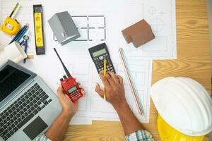 Construction engineers are checking blueprints and calculating their accuracy after receiving plans from architect in order start  construction safely. Inspection Concept from construction engineering photo