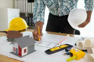 Construction engineers are checking blueprints and calculating their accuracy after receiving plans from architect in order start  construction safely. Inspection Concept from construction engineering photo