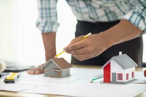 Construction engineers are checking blueprints and calculating their accuracy after receiving plans from architect in order start  construction safely. Inspection Concept from construction engineering photo