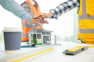 Architects and construction engineering handshake after meeting discuss structural blueprints calculate project completion. cooperation and handshake between of construction engineers and architects. photo