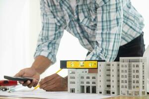 Construction engineers are checking blueprints and calculating their accuracy after receiving plans from architect in order start  construction safely. Inspection Concept from construction engineering photo