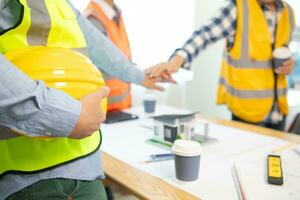 Architects and construction engineering handshake after meeting discuss structural blueprints calculate project completion. cooperation and handshake between of construction engineers and architects. photo