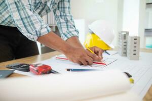 Construction engineers are checking blueprints and calculating their accuracy after receiving plans from architect in order start  construction safely. Inspection Concept from construction engineering photo