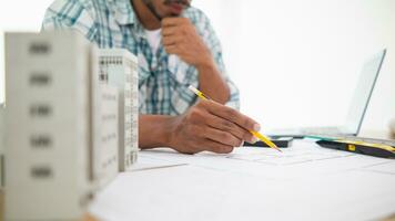 Construction engineers are checking blueprints and calculating their accuracy after receiving plans from architect in order start  construction safely. Inspection Concept from construction engineering photo