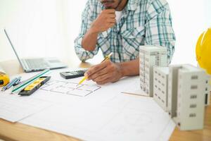 Construction engineers are checking blueprints and calculating their accuracy after receiving plans from architect in order start  construction safely. Inspection Concept from construction engineering photo
