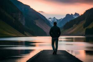 a man standing on a dock looking at the mountains and water. AI-Generated photo