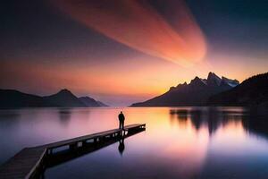 un hombre soportes en un muelle a puesta de sol en frente de montañas. generado por ai foto