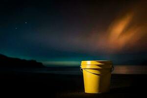 a yellow bucket sitting on the beach at night. AI-Generated photo