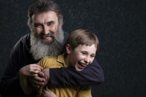 retrato de un contento abuelo con un barba y nieto en un negro antecedentes. foto